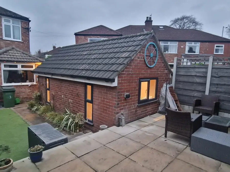 Detached brick garage converted into a room with new windows