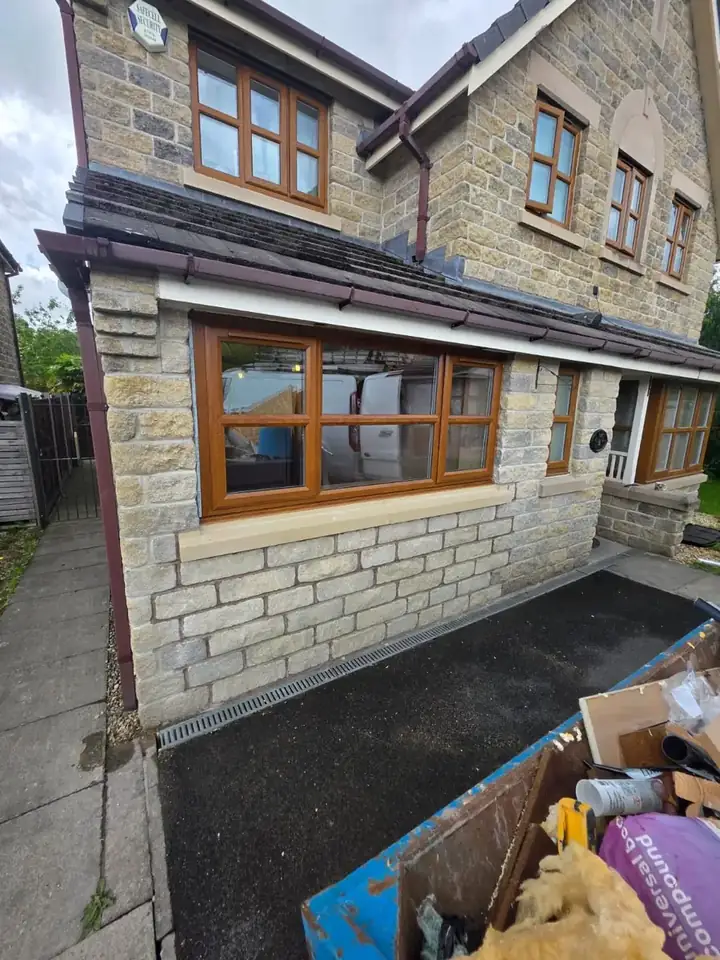 Garage door replaced with a new window and matching stonework