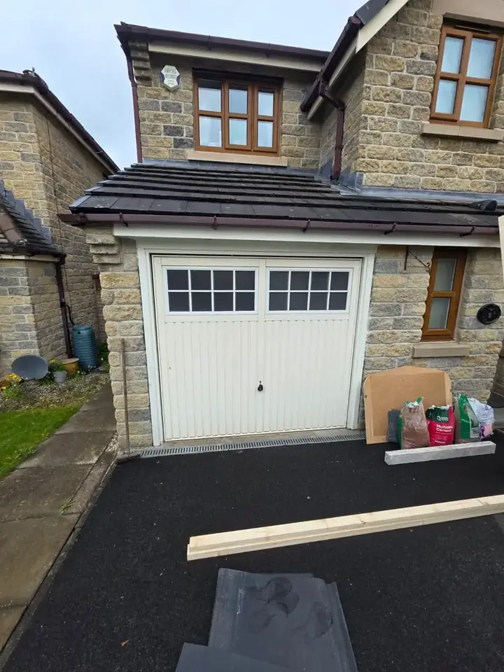 Stone house with a white up and over garage door